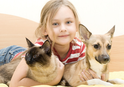 Kind mit Katze und Hund im Arm
